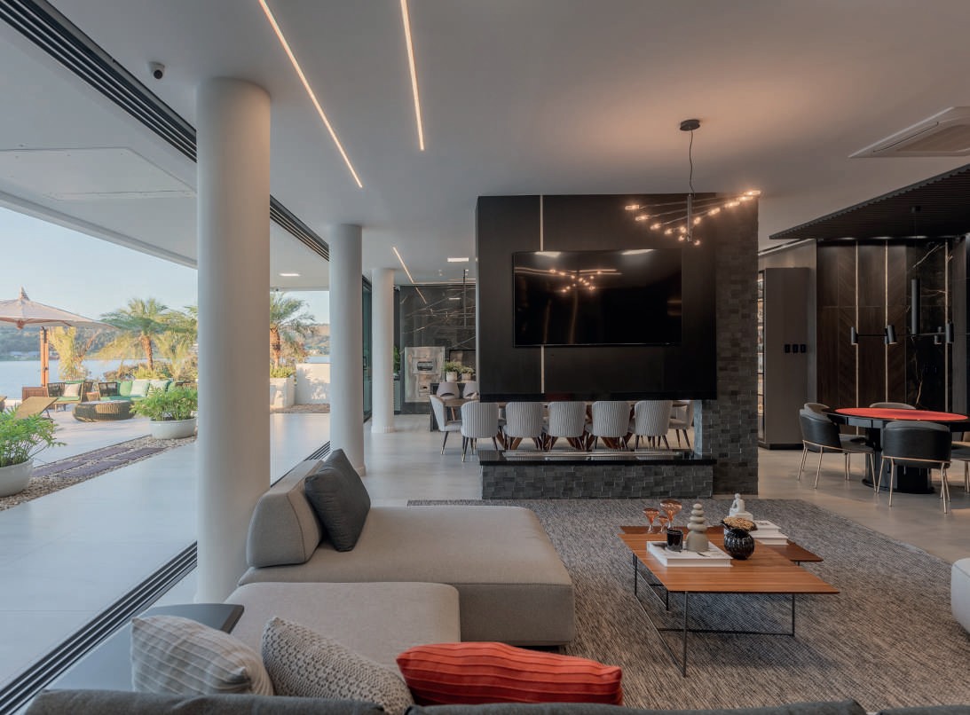 Living integrado com lareira, sala de jogos e vista para a piscina